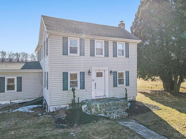 colonial inspired home featuring a front lawn