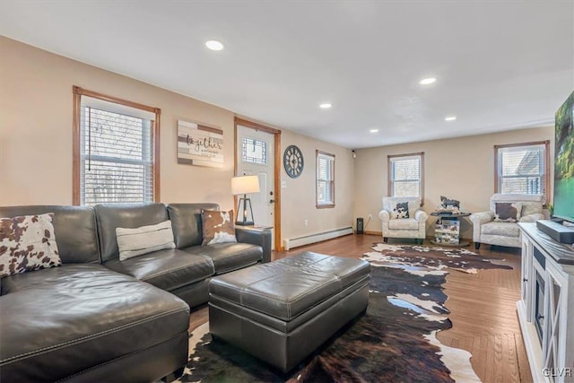 living room featuring a baseboard heating unit and hardwood / wood-style floors