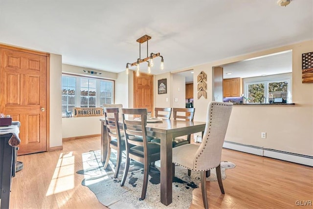 dining space featuring light wood-type flooring and baseboard heating