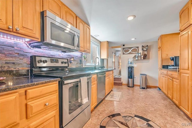 kitchen featuring appliances with stainless steel finishes, sink, and decorative backsplash