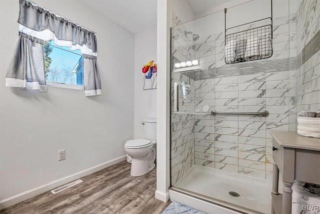 bathroom featuring toilet, hardwood / wood-style floors, and walk in shower