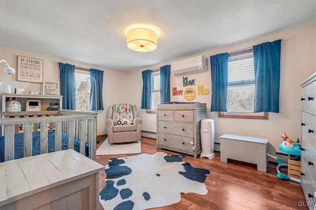 bedroom with multiple windows, a baseboard radiator, hardwood / wood-style floors, and a wall unit AC