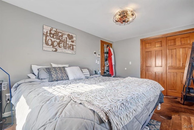 bedroom with dark hardwood / wood-style flooring and a closet