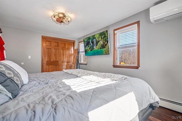 bedroom featuring multiple windows, a wall mounted air conditioner, baseboard heating, and a closet