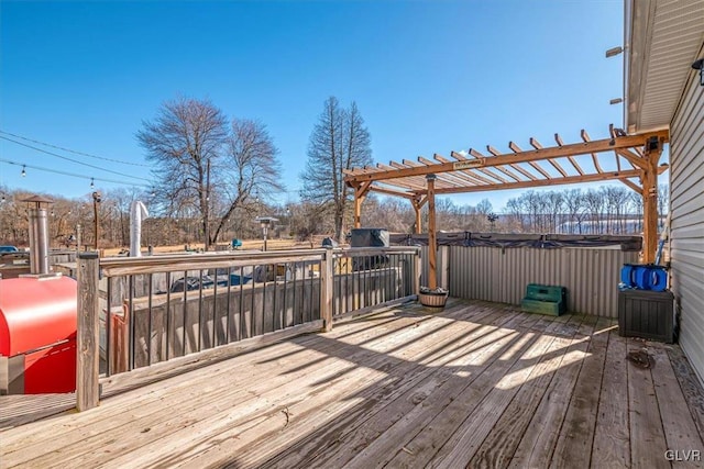 deck with a hot tub and a pergola