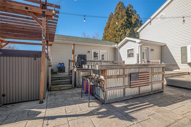 view of patio with a wooden deck, a pergola, a hot tub, and exterior bar