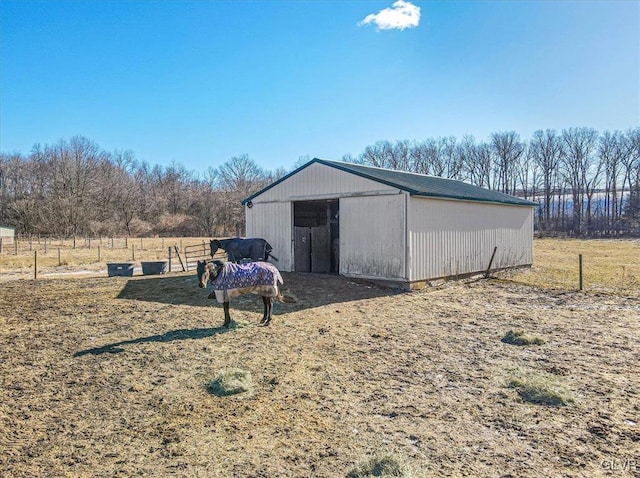 view of outdoor structure with a rural view and a lawn