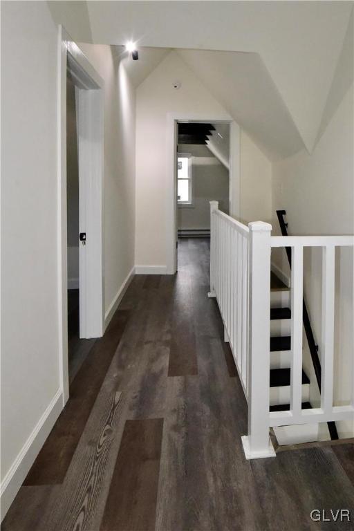 hallway with vaulted ceiling, dark hardwood / wood-style floors, and baseboard heating