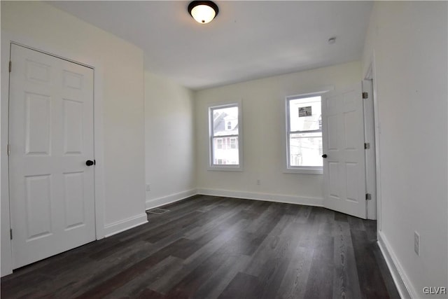 unfurnished room with dark wood-type flooring