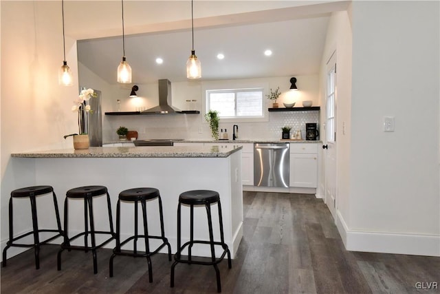 kitchen with tasteful backsplash, white cabinets, stainless steel dishwasher, light stone countertops, and wall chimney exhaust hood