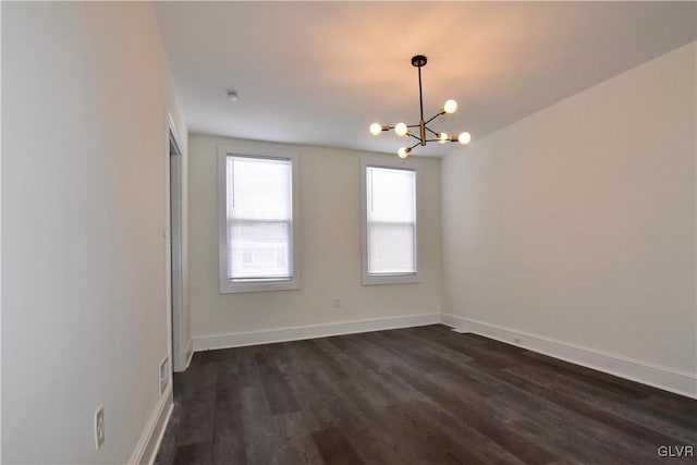 unfurnished room with dark hardwood / wood-style flooring and an inviting chandelier