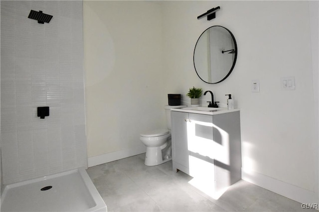 bathroom with tiled shower, vanity, and toilet