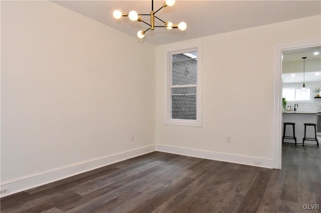 empty room featuring dark hardwood / wood-style floors and a chandelier