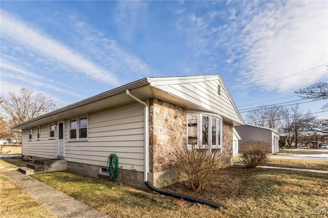 view of side of home with a yard