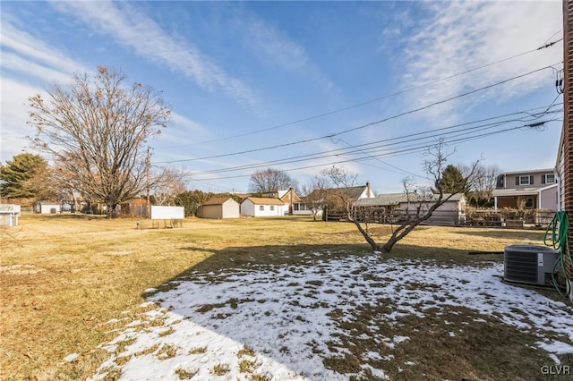 yard covered in snow featuring cooling unit and a storage unit