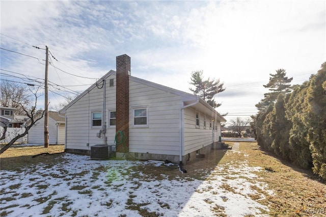 snow covered property featuring central AC unit