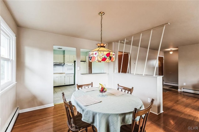 dining area featuring dark hardwood / wood-style flooring and a baseboard heating unit