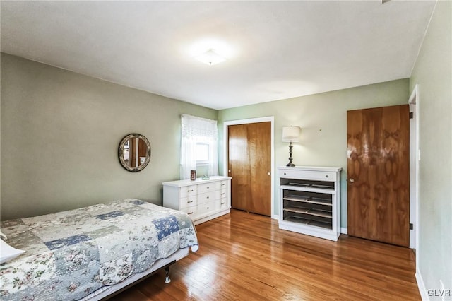 bedroom with hardwood / wood-style floors and a closet