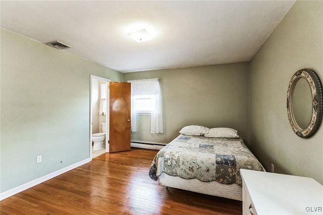 bedroom with a baseboard radiator, hardwood / wood-style floors, and ensuite bath