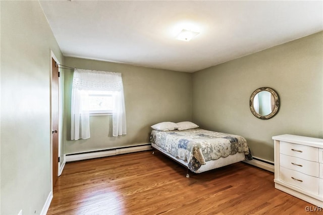 bedroom with a baseboard radiator and light hardwood / wood-style floors