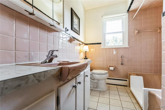 bathroom featuring toilet, tile walls, baseboard heating, vanity, and tile patterned flooring