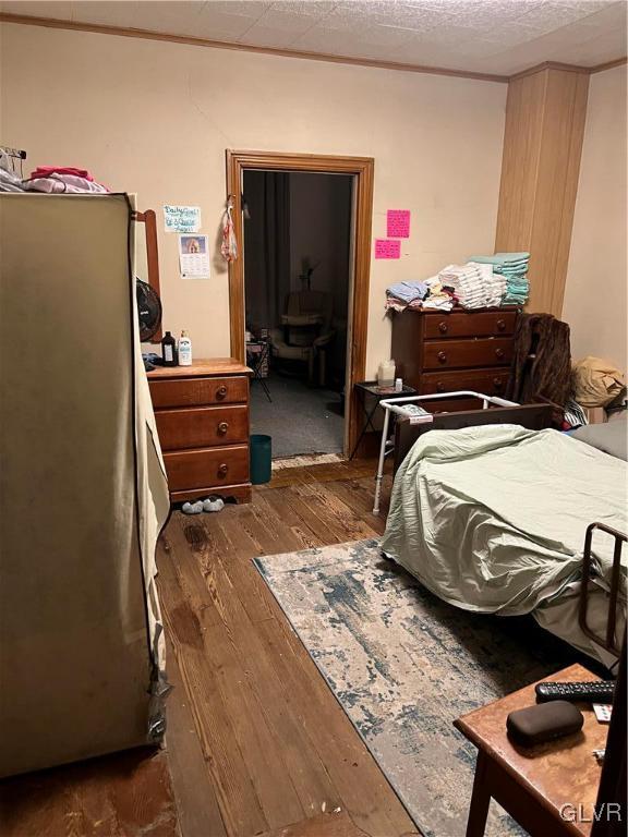 bedroom with ensuite bathroom and dark hardwood / wood-style floors