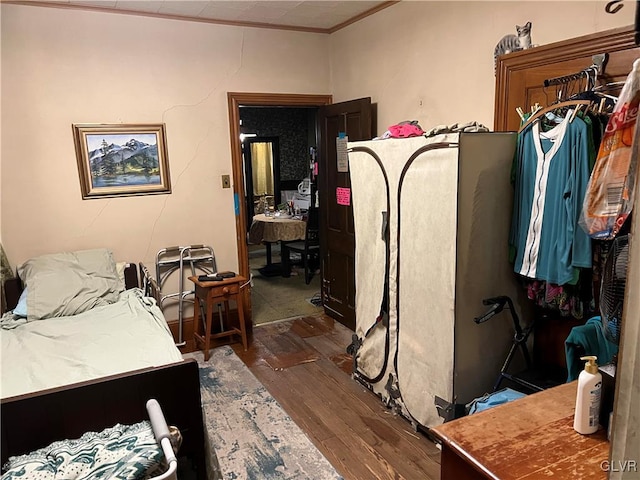 bedroom with crown molding and dark hardwood / wood-style floors