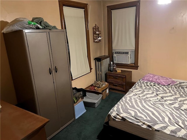 bedroom with cooling unit, radiator heating unit, and dark colored carpet