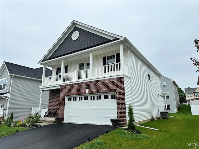 view of front of property featuring a balcony, a garage, a front lawn, and central air condition unit