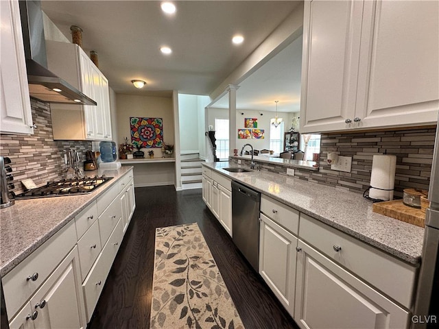 kitchen featuring white cabinetry, stainless steel appliances, sink, and wall chimney range hood