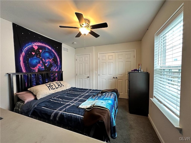 bedroom with ceiling fan, dark carpet, and a closet