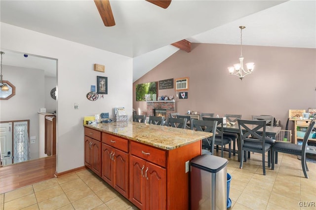 kitchen featuring vaulted ceiling with beams, light stone counters, light tile patterned floors, kitchen peninsula, and pendant lighting