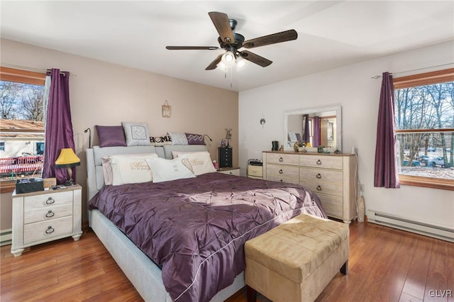 bedroom with a baseboard radiator, dark hardwood / wood-style floors, and ceiling fan