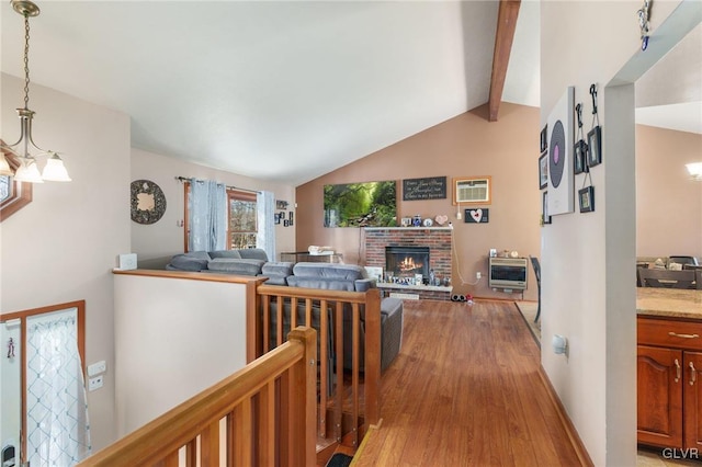 hall featuring an AC wall unit, heating unit, vaulted ceiling with beams, a notable chandelier, and light hardwood / wood-style floors