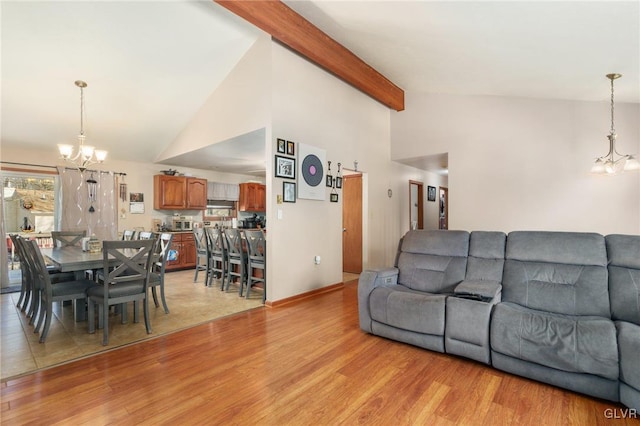 living room featuring beam ceiling, high vaulted ceiling, a chandelier, and light wood-type flooring