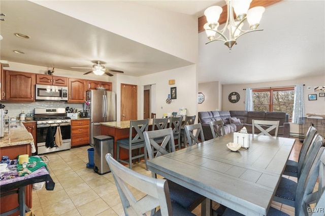 dining space with light tile patterned flooring and ceiling fan with notable chandelier