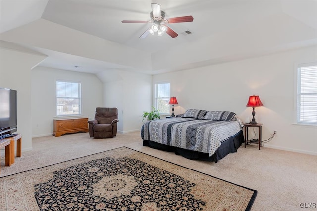 carpeted bedroom featuring a raised ceiling and ceiling fan