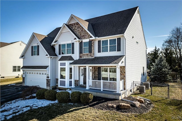 view of front facade with central AC unit, a garage, a front lawn, and a porch