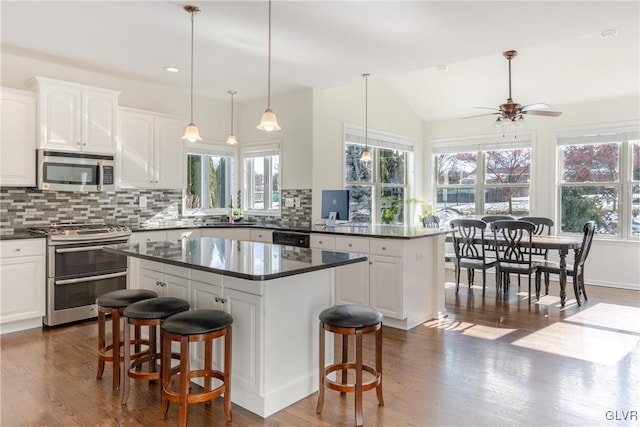 kitchen featuring appliances with stainless steel finishes, a breakfast bar, a kitchen island, and white cabinets