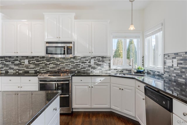 kitchen featuring white cabinetry, sink, dark stone counters, and appliances with stainless steel finishes