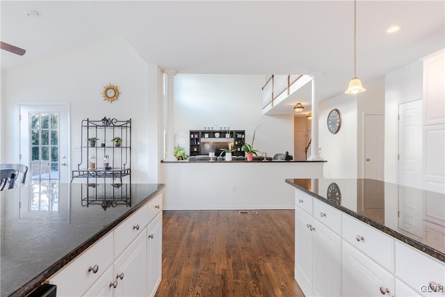 kitchen with dark stone counters, decorative light fixtures, and white cabinets