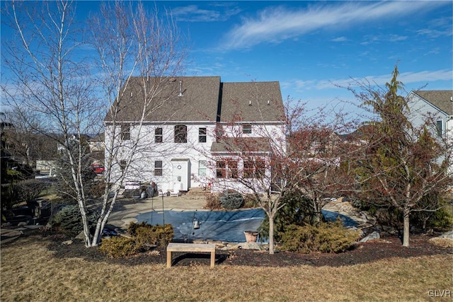 back of property with a yard and a patio area