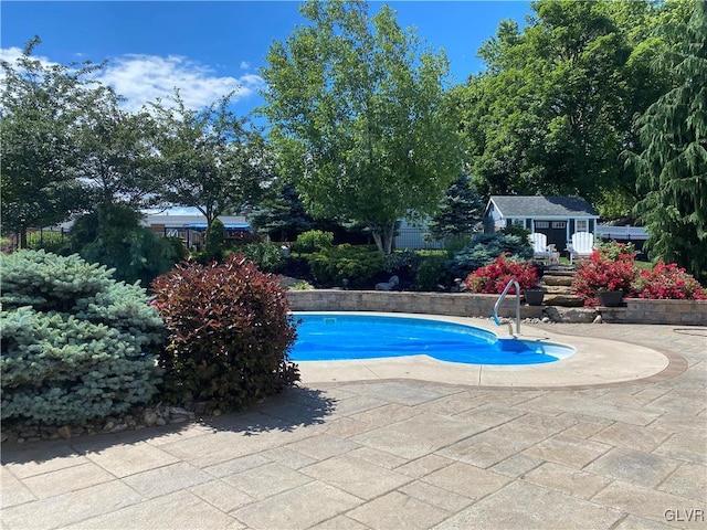 view of pool with a patio and an outdoor structure