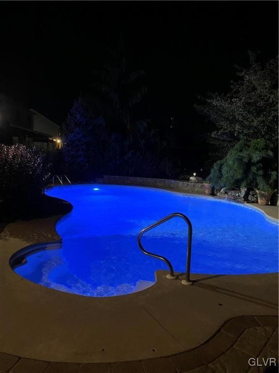 view of pool at twilight