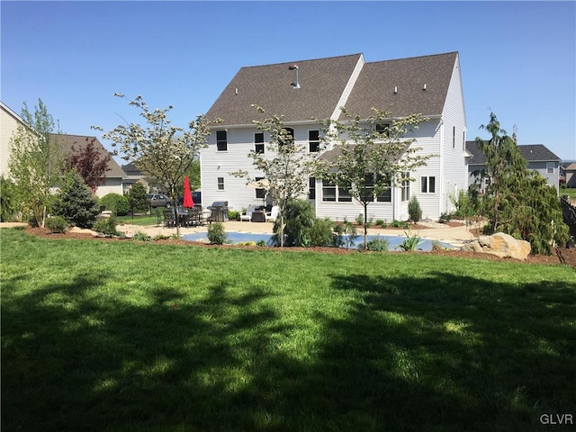 rear view of house featuring a yard and a patio area