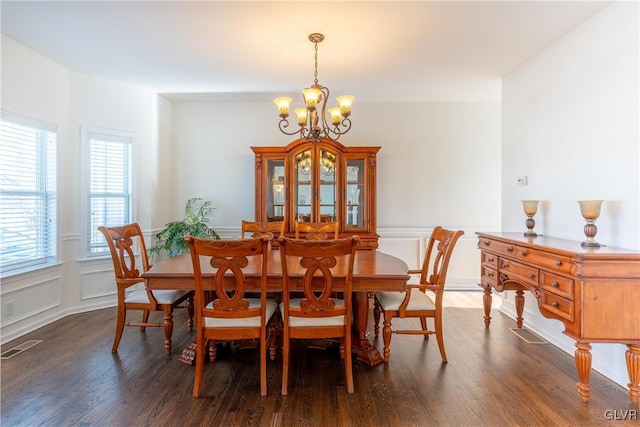 dining room featuring dark hardwood / wood-style flooring and a chandelier