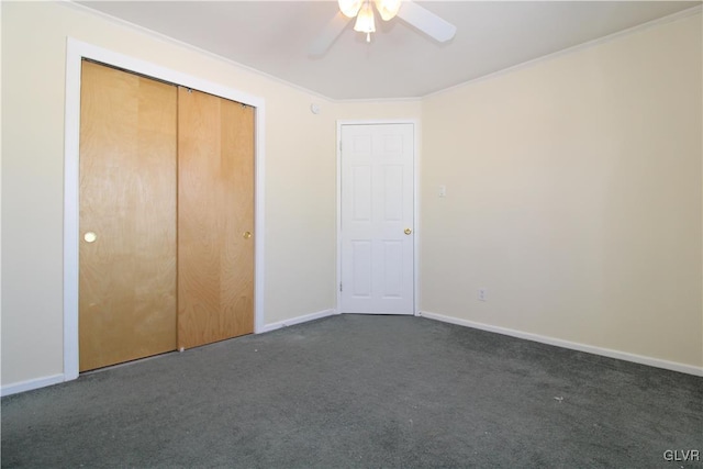 unfurnished bedroom featuring crown molding, ceiling fan, a closet, and dark colored carpet