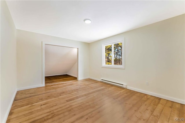 spare room with a baseboard radiator and light hardwood / wood-style flooring