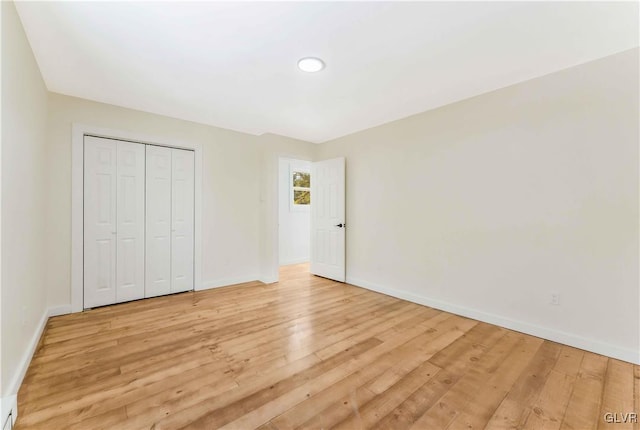 unfurnished bedroom with light hardwood / wood-style floors and a closet