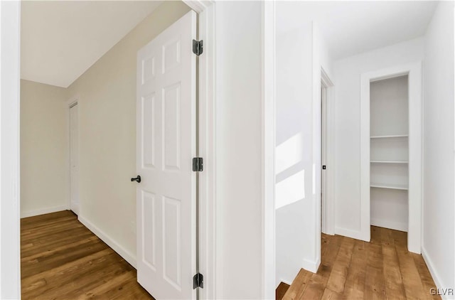 hallway with hardwood / wood-style flooring